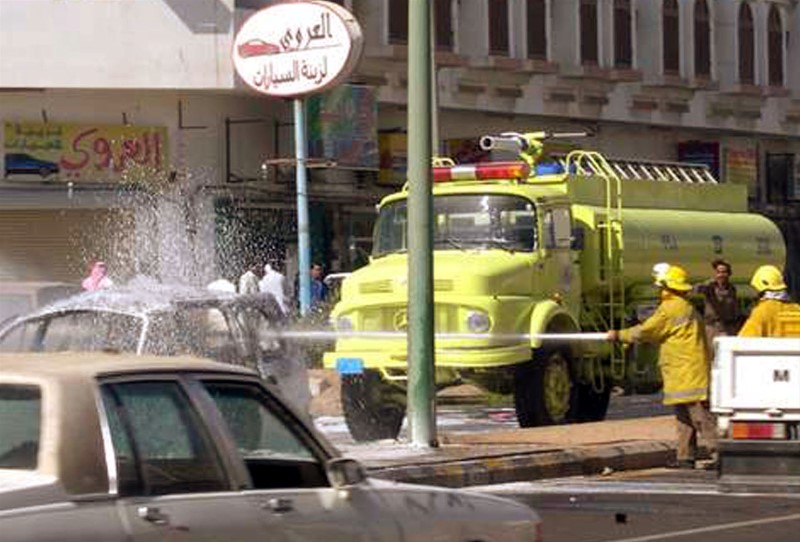 © Reuters. SAUDI FIREFIGHTERS EXTINGUISH CAR OF SUSPECTED MILITANTS AFTER ATTACK IN YANBU.