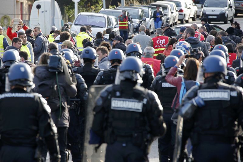 © Reuters. Policiais indo em direção a manifestantes que bloquearam acesso a uma grande refinaria de petróleo na área do porto de Marselha, no sul francês