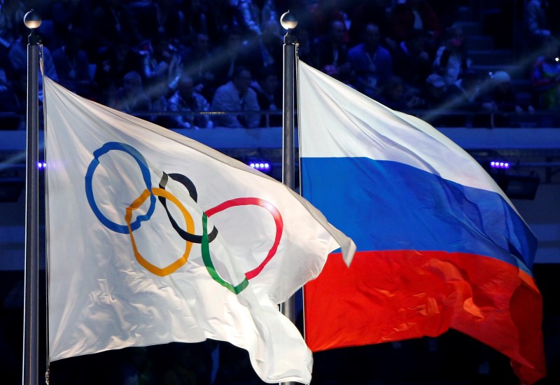 © Reuters. Russian national flag and Olympic flag are seen during closing ceremony for 2014 Sochi Winter Olympics