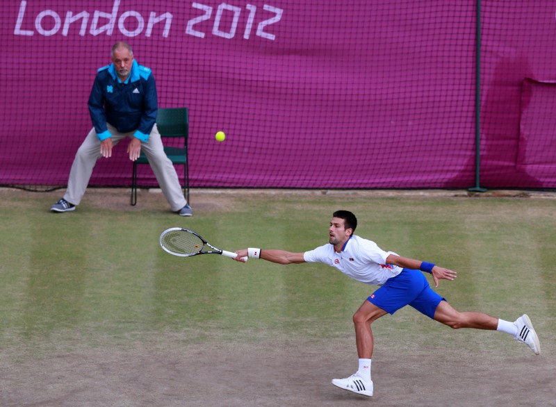 © Reuters. Serbia's Djokovic reaches for a return to Argentina's del Potro in the men's singles tennis bronze medal match at the All England Lawn Tennis Club during the London 2012 Olympic Games