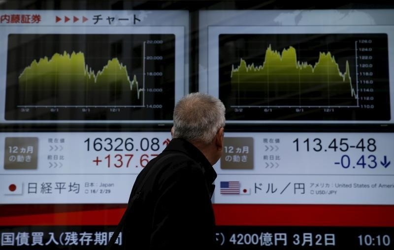 © Reuters. A man looks at an electronic board outside a brokerage in Tokyo