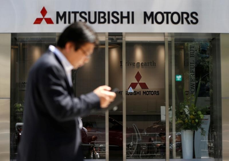 © Reuters. A man walks in front of an entrance of Mitsubishi Motors Corp's headquarters in Tokyo, Japan
