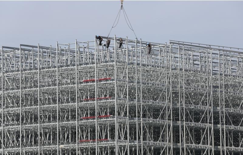 © Reuters. Lavoratori su un edificio in costruzione a Casalpusterlengo, in provincia di Cremona