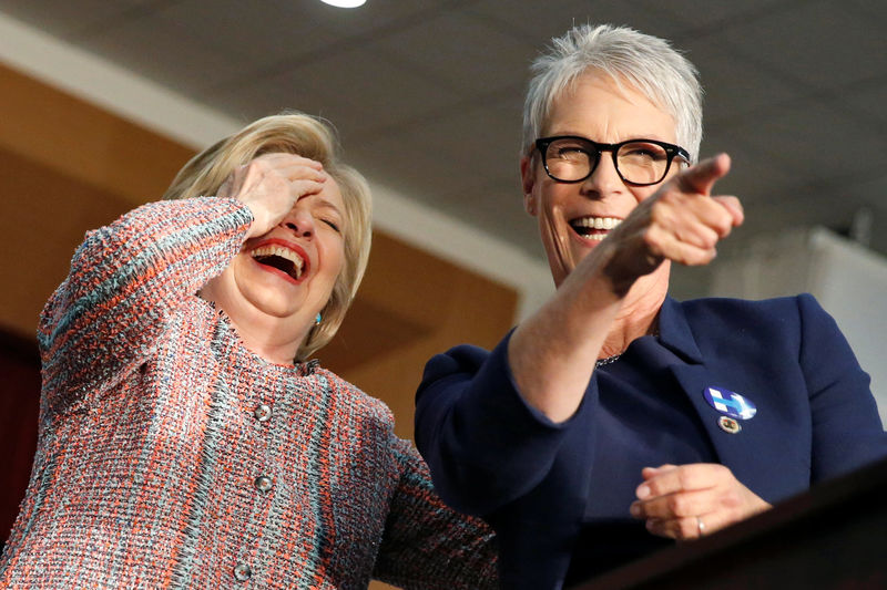 © Reuters. U.S. Democratic presidential candidate Hilary Clinton and actress Jamie Lee Curtis react as two supporters take their tops off at the UFCW Union Local 324 in Buena Park
