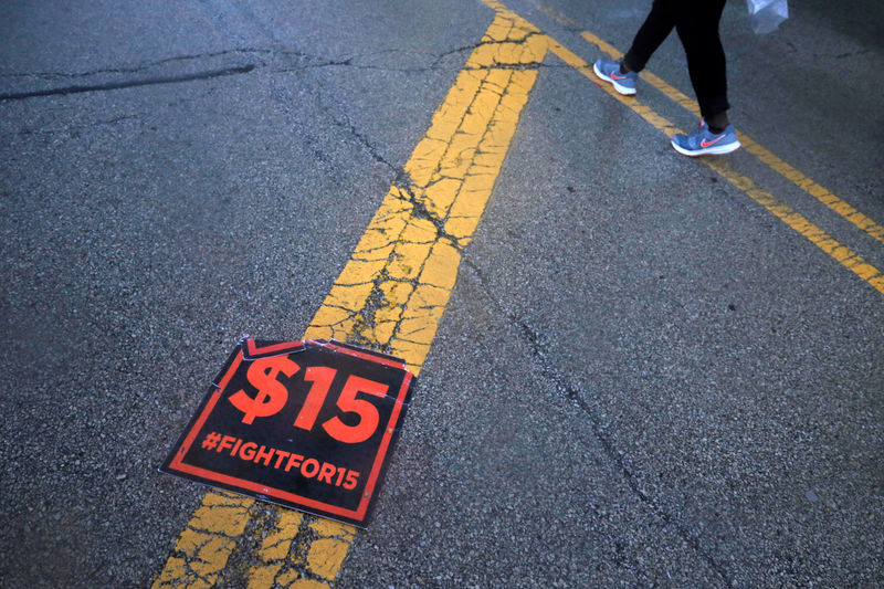 © Reuters. A protester walks past a poster on the ground outside the McDonald's headquarters during a demonstration in the Chicago suburb of Oak Brook