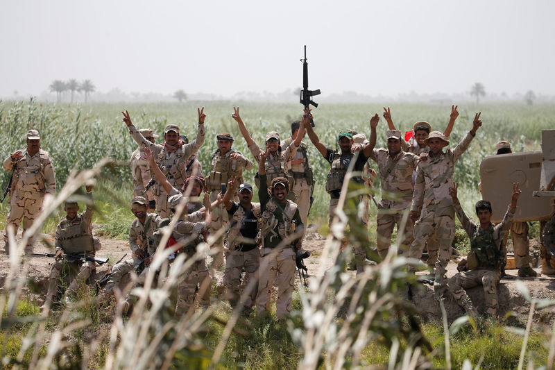 © Reuters. Members of Iraqi security forces gesture near Falluja