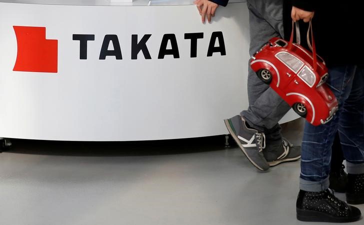 © Reuters. Visitors walk past a logo of Takata Corp on its display at a showroom for vehicles in Tokyo, Japan