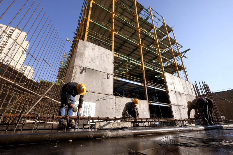 © Reuters. Labourers work at the construction site of a building in Tehran