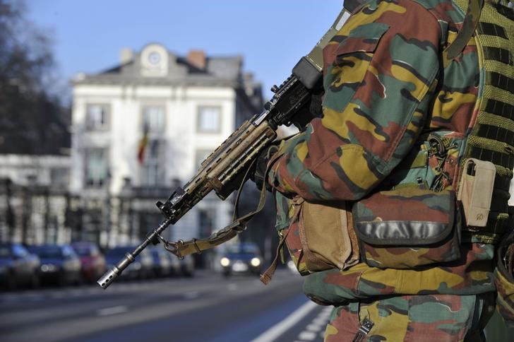 © Reuters. A Belgian paratrooper stands guards outside the U.S. Embassy in Brussels, near the Belgian Parliament