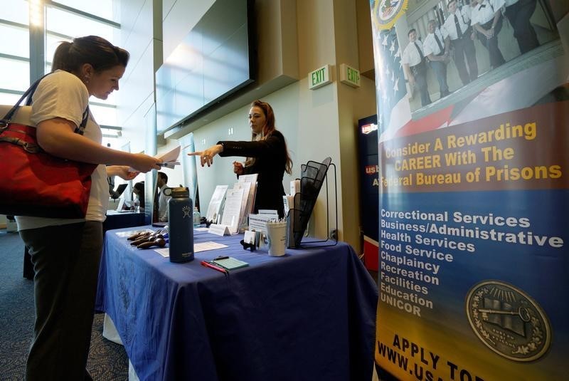 © Reuters. A job seeker listens to a recruiter from the Federal Bureau of Prisons at a health care job fair sponsored by the Colorado Hospital Association in Denver