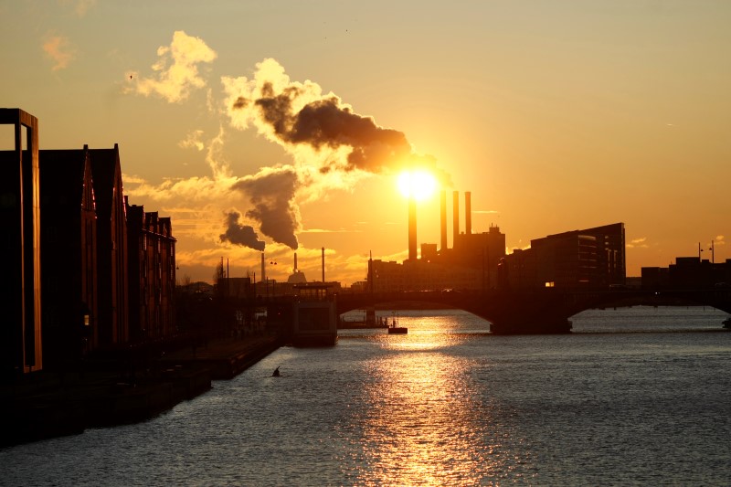 © Reuters. The Sun sets over a smoking power plant near the venue of the UN Climate Change Conference in Copenhagen