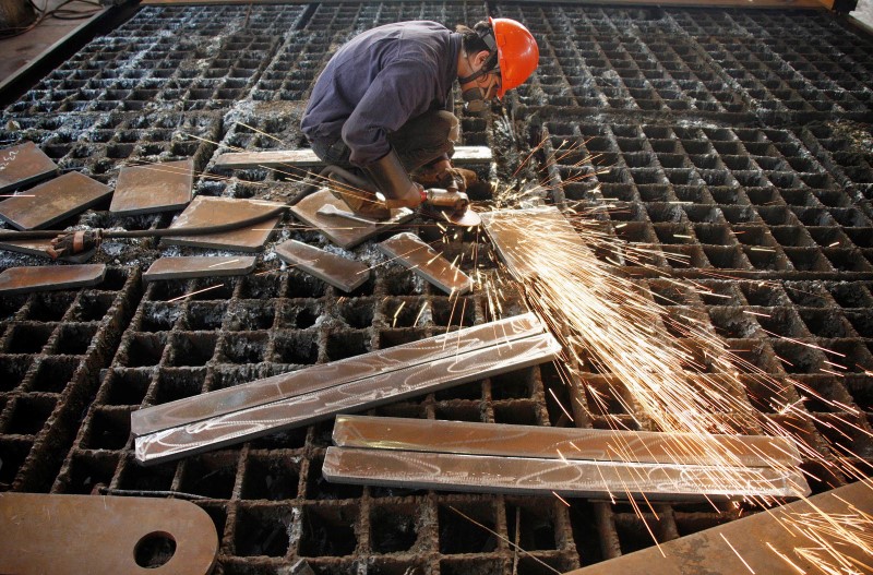 © Reuters. A labourer welds steel frames at a steel factory in Huaibei