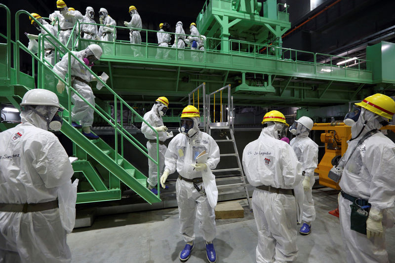 © Reuters. Members of the media and TEPCO employees walk down the steps of a fuel handling machine on the spent fuel pool inside the No.4 reactor building in Fukushima