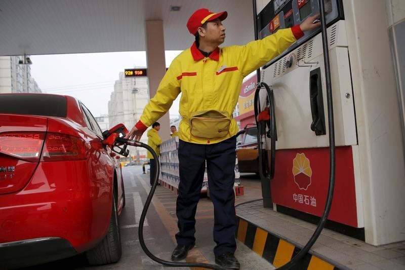 © Reuters. A gas station attendant pumps fuel into a customer's car at PetroChina's petrol station in Beijing