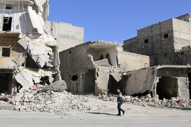 © Reuters. Homem em frente prédios destruídos na cidade síria de Azaz