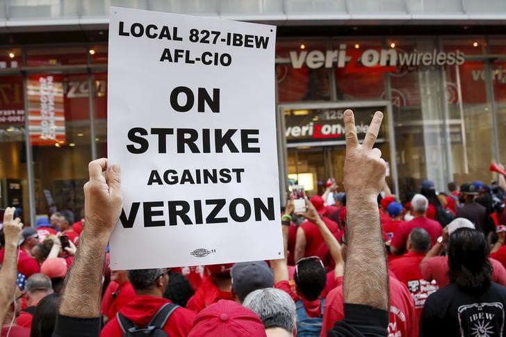 © Reuters. People demonstrate outside a Verizon wireless store during a strike in New York, U.S., April 18, 2016