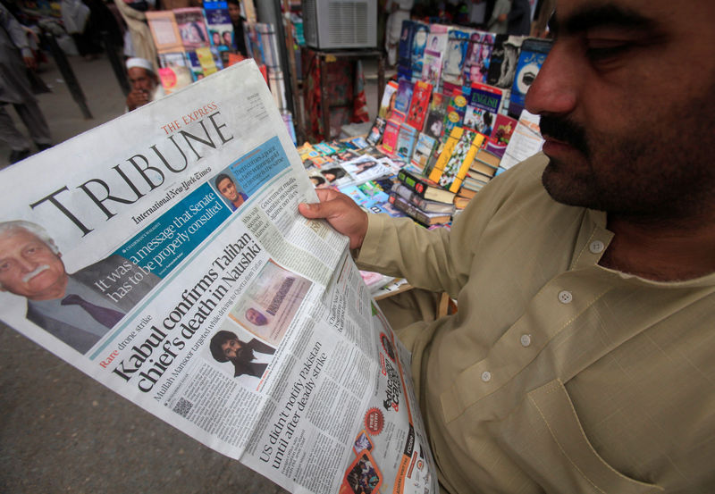 © Reuters. A man reads a newspaper containing news about Afghan Taliban leader Mullah Akhtar Mansour at a stall in Peshawar