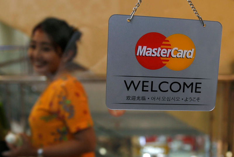 © Reuters. A woman walks past a MasterCard sign at a shopping mall in Jakarta