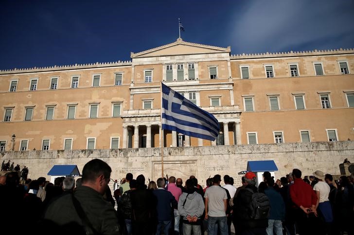 © Reuters. A protester waves a Greek flag during a demonstration outside the parliament building in central Athens