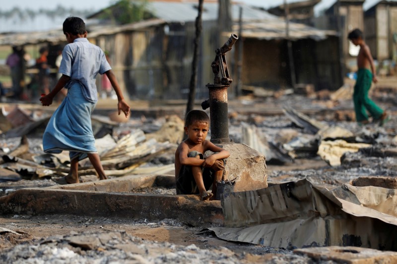 © Reuters. A boy sit in a burnt area after fire destroyed shelters at a camp for internally displaced Rohingya Muslims in the western Rakhine State near Sittwe