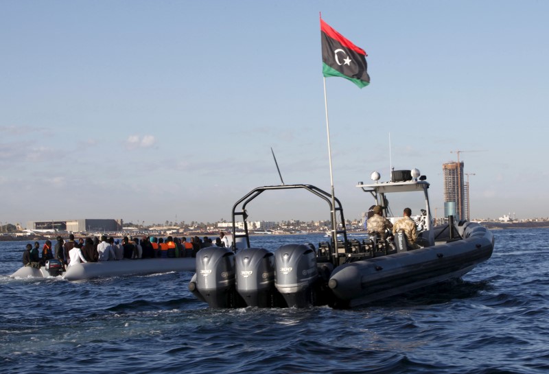 © Reuters. Libyan coast guards escort migrants, who tried to flee to Europe, after the migrants were stopped by the coast guards and made to head to Tripoli