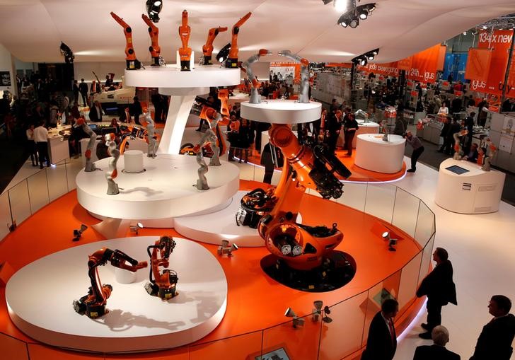 © Reuters. Visitors watch different sized industrial robots by KUKA at the Hanover Messe