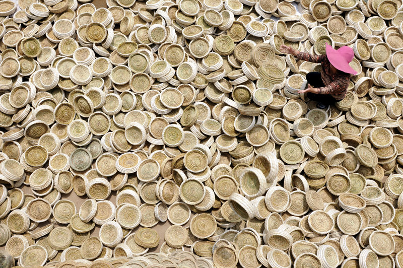 © Reuters. A worker puts aside handicrafts of bird nests as she sits among them in Linyi