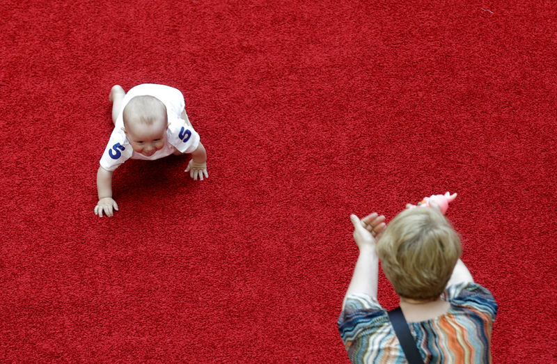 © Reuters. A mother reacts as her baby takes place in the Baby Race to mark international Children's Day in Vilnius