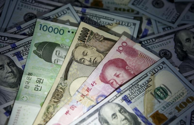 © Reuters. South Korean won, Chinese yuan and Japanese yen notes are seen on U.S. 100 dollar notes in this picture illustration taken in Seoul