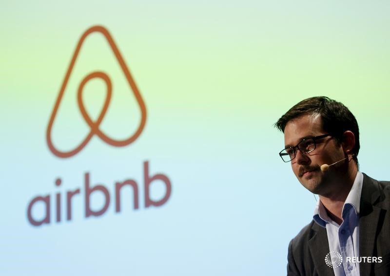 © Reuters. Orgill, Airbnb's Director of Public Policy in APAC, speaks in front of a screen displaying a logo of the company during a news conference in Tokyo