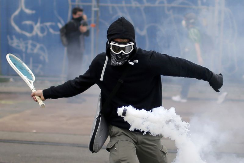 © Reuters. Manifestante rebatendo lata de gás com raquete de tênis durante protesto contra reforma das leis trabalhistas na França