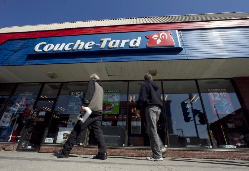 © Reuters. Pedestrians walk past a Couche-Tard convenience store in Montreal