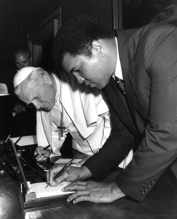 © Reuters. Foto de archivo del Papa Juan Pablo II y la leyenda del boxeo Muhammad Ali firmando autógrafos tras una audiencia en el Vaticano