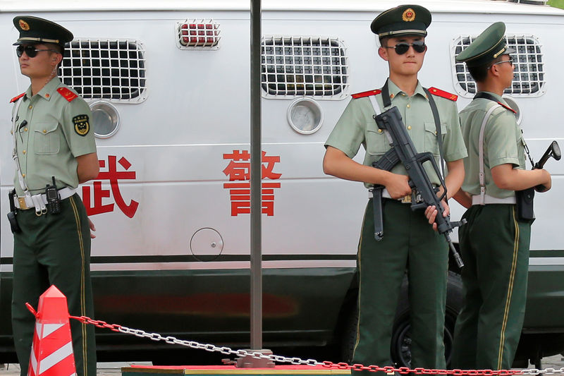 © Reuters. Paramilitary policemen hold weapons as they provide security near Tiananmen Square in Beijing