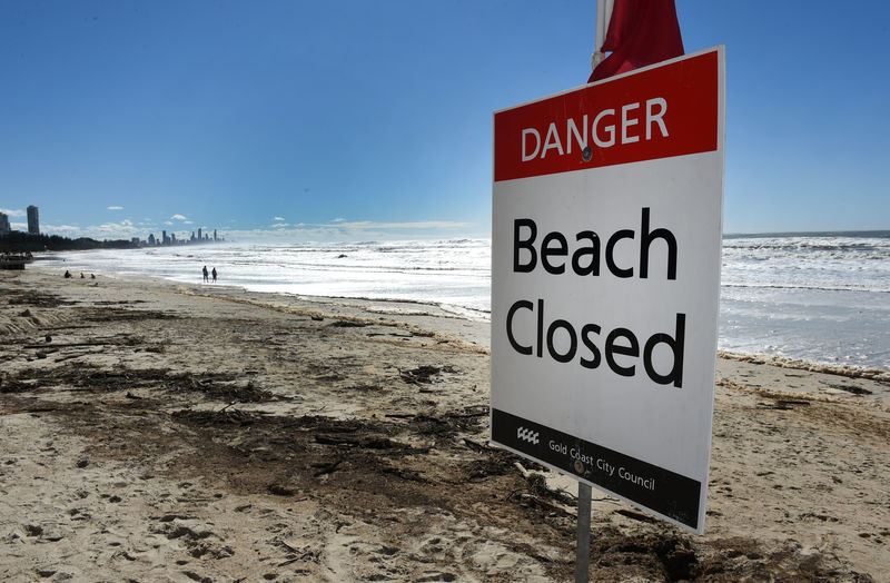 © Reuters. A sign is displayed on a beach that was closed due to dangerous surf conditions at Burleigh Heads on Queensland's Gold Coast, Australia