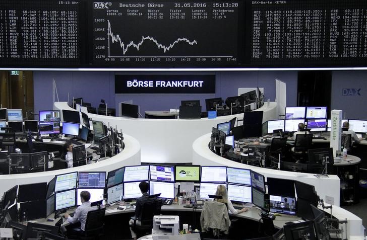 © Reuters. Traders work at their desks in front of the German share price index, DAX board, at the stock exchange in Frankfurt