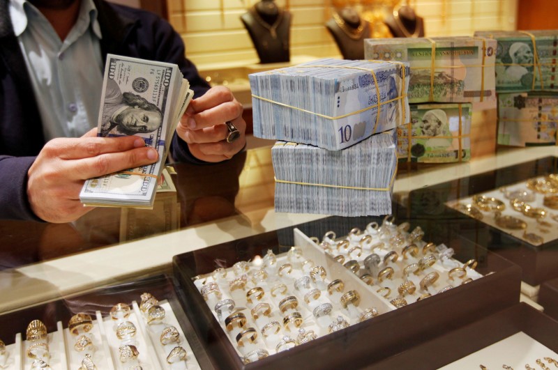 © Reuters. A man counts U.S. dollars at a currency exchange office in Tripoli