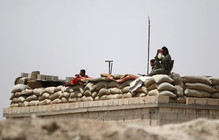 © Reuters. Fighters of the Syria Democratic Forces take an overwatch position in northern province of Raqqa