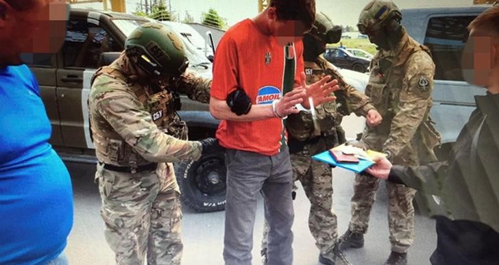 © Reuters. Members of Ukraine's state security service detain French citizen who had been planning attacks in France to coincide with the Euro 2016 football championship it is hosting on Ukrainian-Polish border in Volyn region