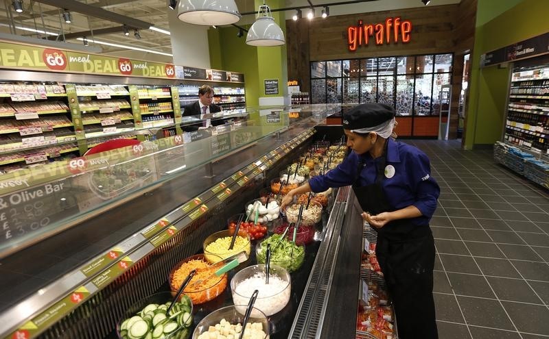 © Reuters. A Tesco employee prepares the salad bar outside the Giraffe restaurant at a Tesco Extra supermarket in Watford, north of London