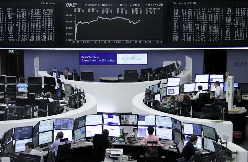 © Reuters. Traders work at their desks in front of the German share price index, DAX board, at the stock exchange in Frankfurt