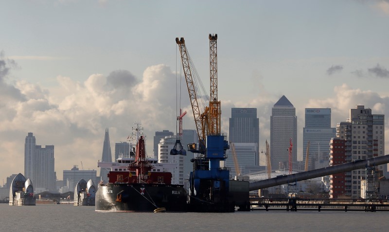 © Reuters. Cranes are used to unload the bulk carrier Wulin at the Tate and Lyle sugar refinery in front of London's financial district of Canary Wharf