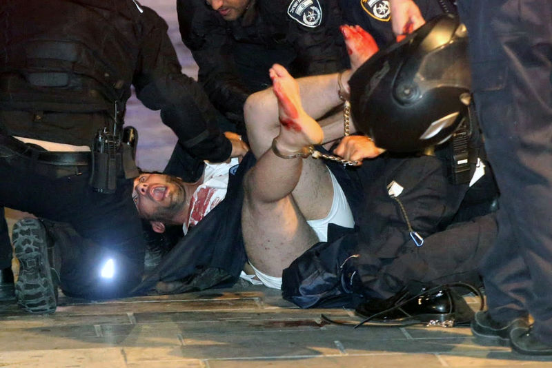 © Reuters. Israeli policemen arrest a suspected man following a shooting attack that took place in the center of Tel Aviv