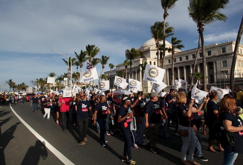 © Reuters. Members of labor unions march past the capitol building during a protest in San Juan