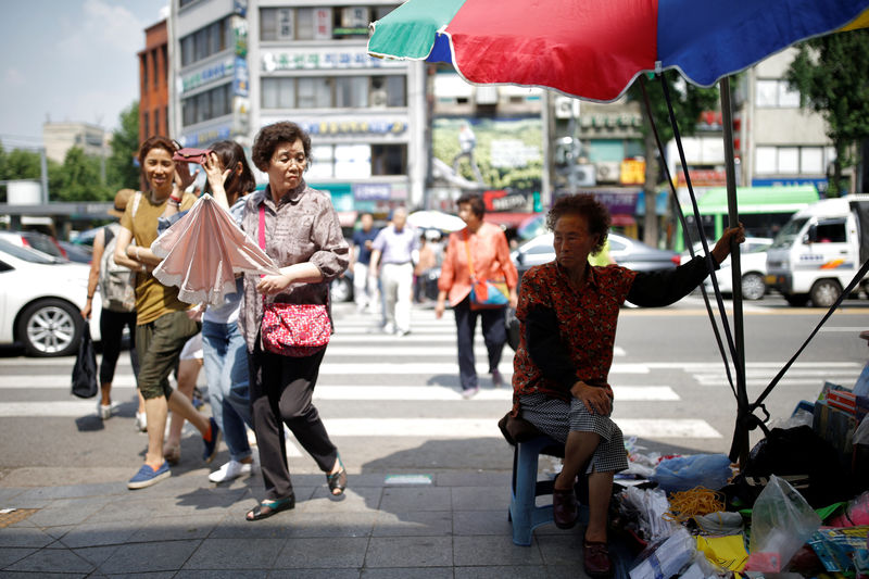 © Reuters. A street vendor waits for a customer in Seoul