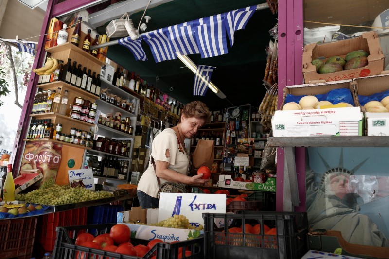 © Reuters. A woman buys tomatoes in a grocery market in central Athens