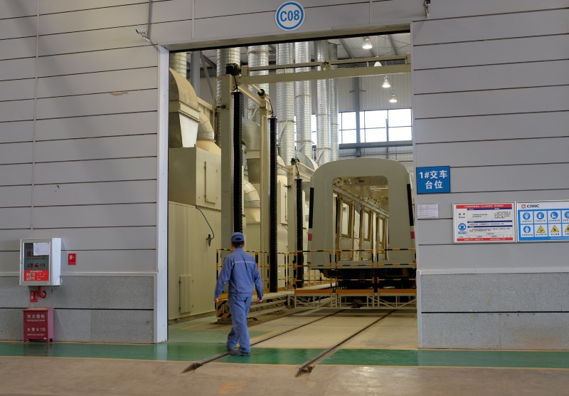 © Reuters. A CRRC worker walks past an unfinished metro train car in the company's Kunming factory