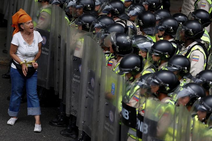 © Reuters. Manifestante da oposição em frente tropa de choque da polícia durante protesto em Caracas