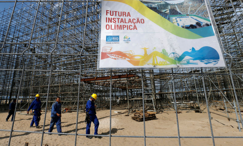 © Reuters. Workers are pictured at the construction site of the beach volleyball venue for 2016 Rio Olympics on Copacabana beach in Rio de Janeiro