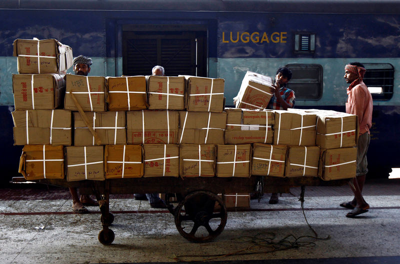 © Reuters. Porters prepare to load goods onto a train at a railway station in Kolkata